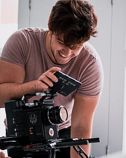 zâmbitor, om, utilizând, cameră video, persoană, uman, aparat foto, Electronică, fotografie, oameni, camera digitala, în interior, design interior, afişa, Monitor, ecran LCD, ecran, fotograf, portret, față, calculator, PC, o persoana, tehnologie, vedere din față, fotografii tematice, tânăr adult, Barbat tanar, aparat de fotografiat - echipament fotografic, deținere, stiluri de viață, haine casual, oameni adevărați, bărbați, echipament fotografic, Activitatea de agrement, permanent, ocupaţie, filmare, 2K, CC0, domeniu public, fără drepturi de autor