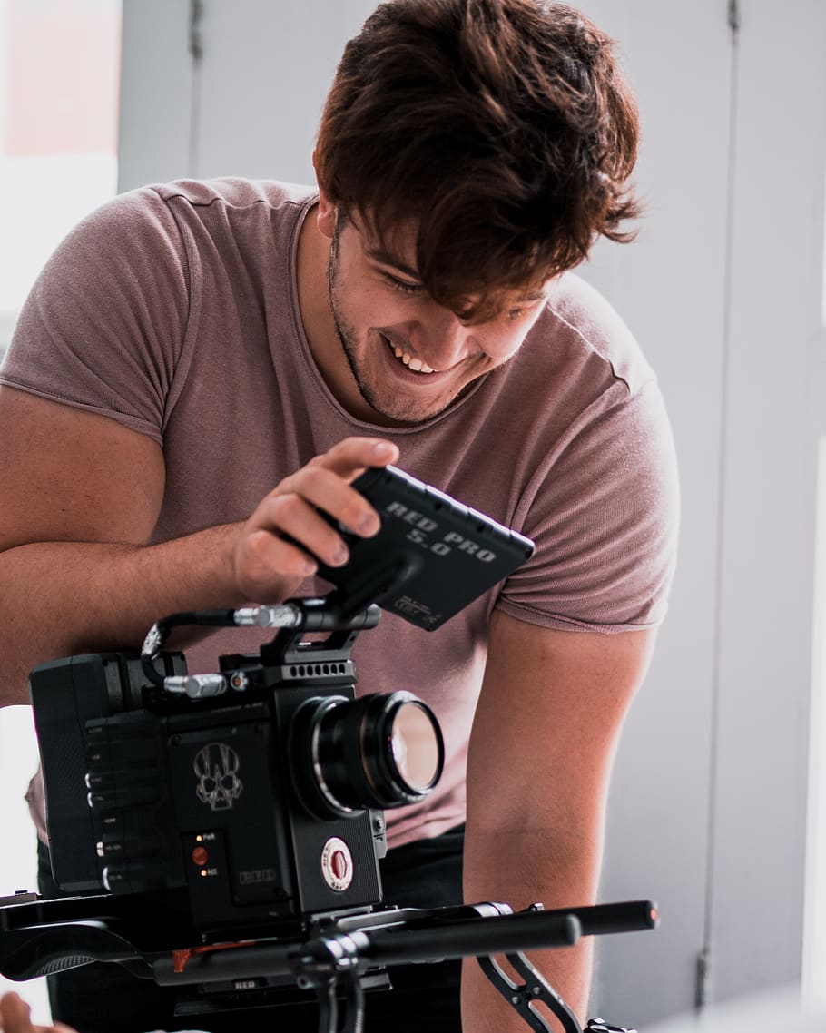 zâmbitor, om, utilizând, cameră video, persoană, uman, aparat foto, Electronică, fotografie, oameni, camera digitala, în interior, design interior, afişa, Monitor, ecran LCD, ecran, fotograf, portret, față, calculator, PC, o persoana, tehnologie, vedere din față, fotografii tematice, tânăr adult, Barbat tanar, aparat de fotografiat - echipament fotografic, deținere, stiluri de viață, haine casual, oameni adevărați, bărbați, echipament fotografic, Activitatea de agrement, permanent, ocupaţie, filmare, 2K