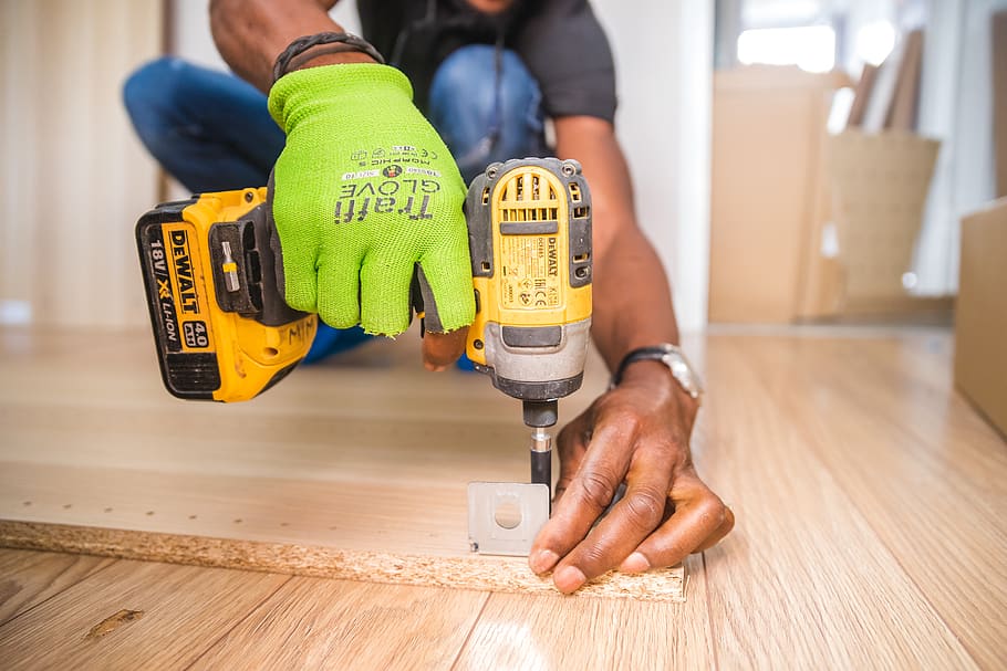 persona, utilitzant, dewalt, sense fils, controlador d’impacte, marró, pissarra, fuster, fusteria, primer pla, construcció, trepant, caps de perforació, equipament, pis, guant, handyman, interior, endins, home, eines elèctriques, eina, desgast, fusta, treballador, treball, mà humana, part del cos humà, ocupació, a l'interior, una persona, mà, industria de la construcció, celebració, homes, interior de casa, eina de treball, adult, indústria, sòls, diy, millores per a la llar, 2K