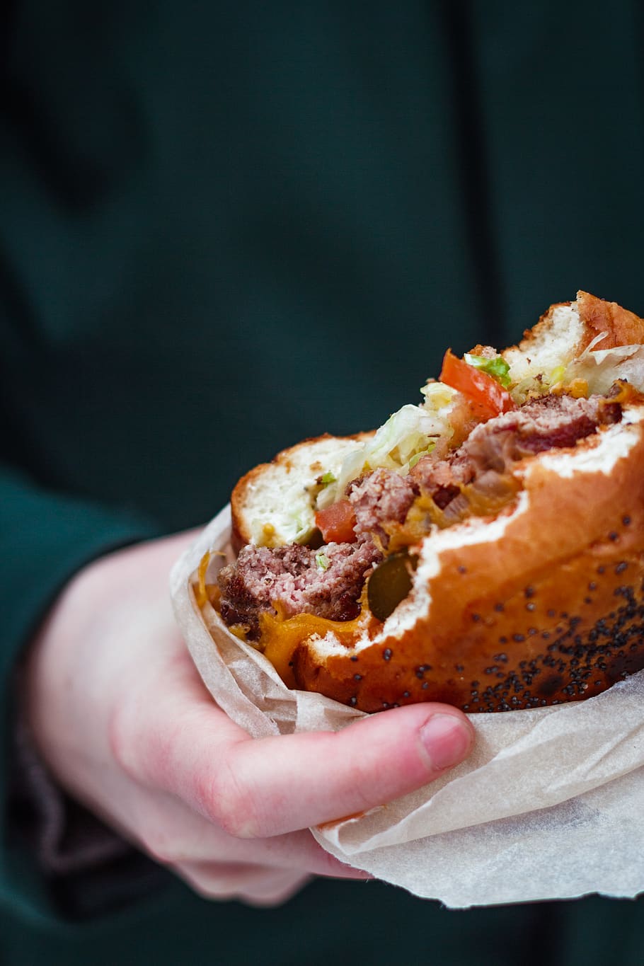 mossegat, hamburguesa, verdures, vedella, pa, cheeseburger, primer pla, deliciós, sopar, epicure, menjar ràpid, menjar, fotografia de menjar, menjar natural, mà, dinar, carn, entrepà, berenar, menjar de carrer, saborós, mà humana, menjar i beguda, celebració, part del cos humà, una persona, frescor, llest per menjar, tir de l'estudi, centrar-se en primer pla, alimentació saludable, secció mitjana, a l'interior, fruita, menjar còmode, 5K