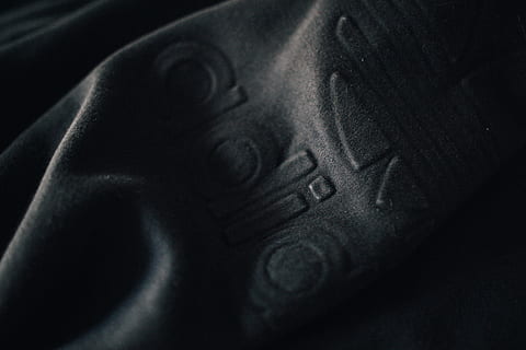 grå tekstil, tøj, beklædning, mode, struktur, pattedyr, dyr, hunde, kæledyr, hund, logo, varemærke, symbol, linsedæksel, moderne, tre striber, hættetrøje, mørk, sort, adidas, tæt på, menneskelig kropsdel, en person, sort farve, indendørs, kropsdel, voksen, rigdom, sort baggrund, portræt, teknologi, tekstureret, meddelelse, arkitektur, studio skud, kunstkultur og underholdning, hovedskud, tekstureret effekt, luksus, menneskeligt ansigt, 4K, CC0, offentligt domæne, royaltyfrie