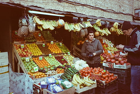 man, standing, store, assorted, bargain, commerce, displayed, food, fresh vegetable, fruit, fruits, market, marketplace, merchandise, merchant, sale, sell, selling, shopping, stall, stocks, food and drink, retail, healthy eating, choice, freshness, business, wellbeing, variation, one person, vegetable, abundance, market stall, adult, banana, buying, groceries, retail display, 2K, CC0, public domain, royalty free