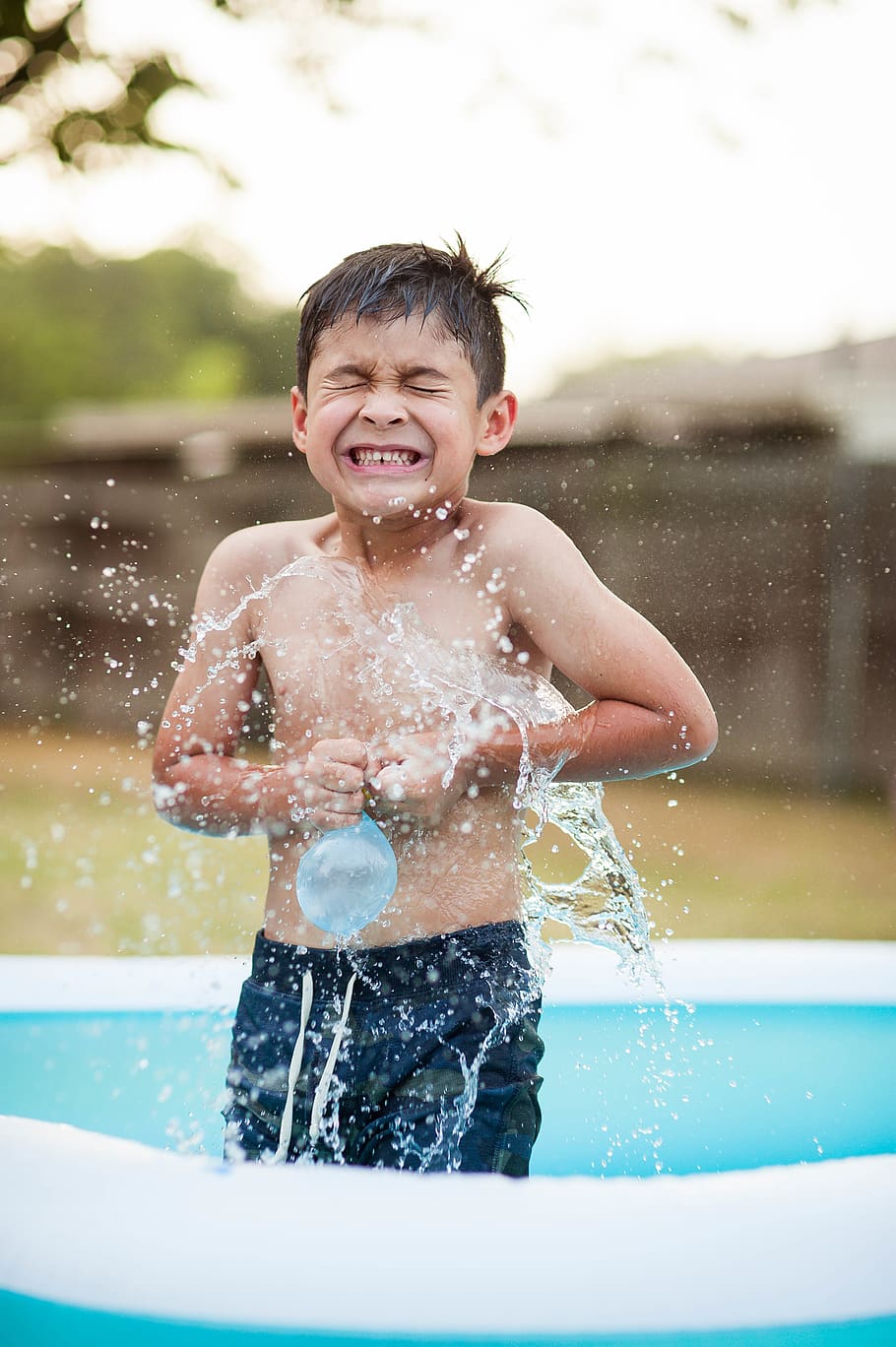 noi, jugant, globus de plàstic, endins, piscina inflable, infància, nen, una persona, persones reals, moviment, aigua, mascles, vista frontal, nois, esquitxades, dia, diversió, naturalesa, innocència, felicitat, emoció, centrar-se en primer pla, boca oberta, a l'aire lliure, fumigació, 4K