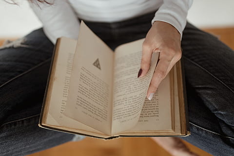 beautiful, young, woman reading, book, adult, caucasian, female, girl, woman, relaxing, reading, indoor, student, midsection, one person, paper, publication, activity, holding, indoors, text, human hand, sitting, hand, human body part, communication, high angle view, men, casual clothing, note pad, studying, jeans, 4K
