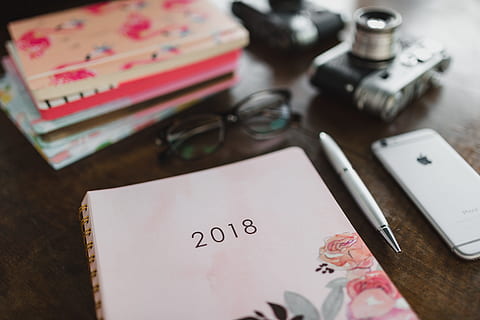 pink calendar, calendar, notebook, diary, note, desk, table, indoors, high angle view, pen, text, scissors, business, close-up, no people, still life, furniture, communication, selective focus, note pad, writing instrument, paper, preparation, western script, 5K, CC0, public domain, royalty free