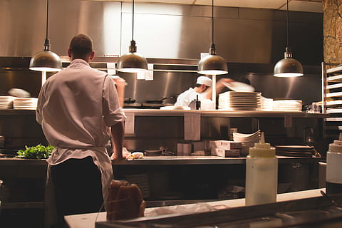restaurant, kitchen, chefs, cooks, food, culinary, real people, indoors, occupation, men, food and drink, business, rear view, commercial kitchen, working, preparation, standing, arrangement, people, store, choice, shelf, three quarter length, chef, preparing food, uniform, 5K