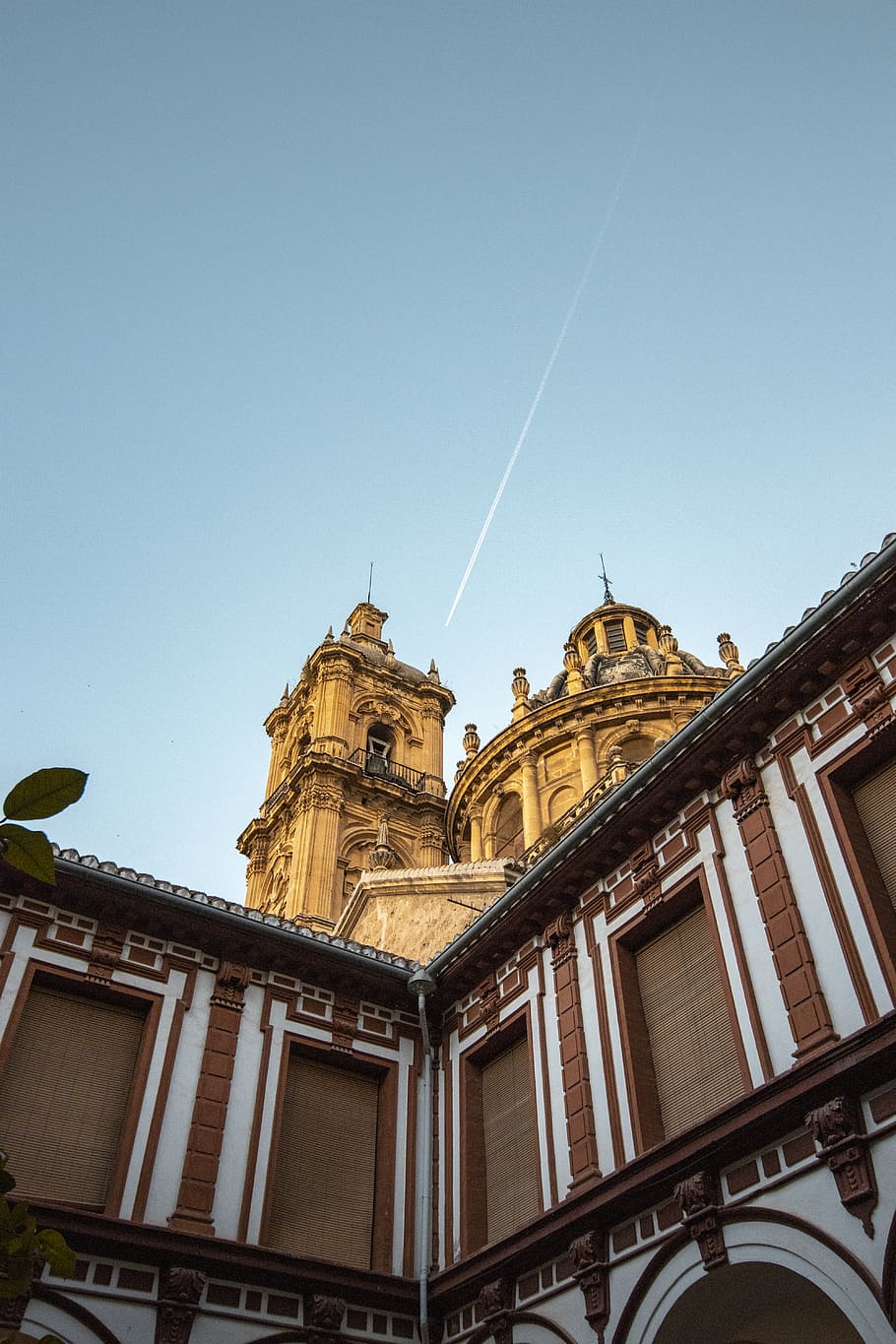 edificio in cemento marrone, cielo, granada, Cattedrale, aereo, esterno dell'edificio, architettura, struttura costruita, costruzione, Inquadratura dal basso, cielo sereno, religione, luogo di culto, il passato, storia, credenza, spiritualità, nessuno, cupola, natura, giorno, destinazioni di viaggio, scia di vapore, ornato, guglia, 5K