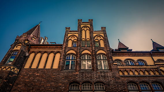 Lübeck, architettura, facciata, finestra, costruzione, vecchio, mattone, centro storico, cielo, luce, struttura costruita, esterno dell'edificio, Inquadratura dal basso, luogo di culto, spiritualità, credenza, religione, destinazioni di viaggio, nessuno, storia, il passato, cielo sereno, viaggio, turismo, arco, all'aperto, ornato, stile gotico, guglia, 5K, CC0, dominio pubblico, privo di copyright