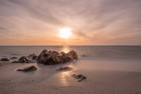núvols, cel, sol, posta de sol, sortida del sol, oceà, mar, sorra, aigua, roques, vacances, estiu, horitzó sobre l’aigua, horitzó, escenics - natura, bellesa a la natura, platja, terra, núvol - cel, rock, tranquil·litat, escena tranquil·la, rock - object, sòlid, exposició llarga, naturalesa, idíl·lic, cap gent, a l'aire lliure, 5K, CC0, domini públic, lliure de regalies