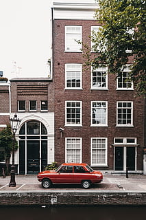 rosso, parcheggio della berlina, accanto, grattacielo, costruzione, giorno, albero, finestra, auto, auto rossa, vecchia macchina, strada, mattone, cittadina, città, urbano, corso d'acqua, canale, vecchio, Vintage ▾, retrò, classico, acqua, fuji, architettura, scena urbana, esterno dell'edificio, facciata, all'aperto, struttura costruita, mezzi di trasporto, paesaggio urbano, Olanda, amsterdam, vecchio stile, vita di città, nessuno, storia, Europa, Casa, modalità di trasporto, editoriale, viaggio, in stile retrò, posto famoso, 5K, CC0, dominio pubblico, privo di copyright