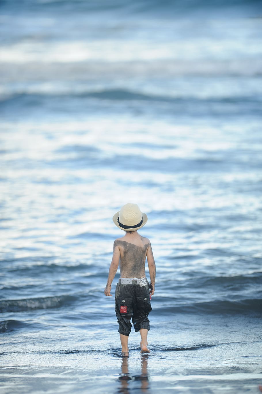 dreng stående strand, beklædning, tøj, human, person, solhat, hat, shorts, cowboy hat, tilbage, klippe, udendørs, ocean, natur, hav, vand, forbjerg, årer, padle, motorhjelm, hæl, rigtige mennesker, bagfra, en person, jord, strand, stående, fritidsaktivitet, livsstil, ferier, skønhed i naturen, bevægelse, dag, bølge, 4K