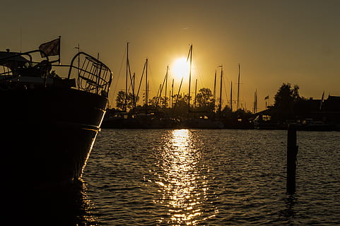 Marrone, bianca, barca, corpo, acqua, porto, porta, tramonto, cielo, sole, riflessione, nessuno, natura, mezzi di trasporto, architettura, lungomare, luce del sole, silhouette, nave nautica, colore arancione, struttura costruita, la tranquillità, all'aperto, modo di trasporto, bellezza nella natura, barca a vela, attrezzatura da costruzione, 4K, CC0, dominio pubblico, privo di copyright