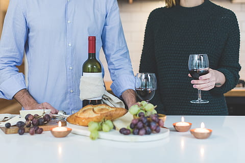 man, standing, beside, woman, holding, wine glass, front, grapes, bread, table, alcohol, bottle, drinking, drinks, fruits, indoors, mushrooms, people, person, red wine, wine, wine bottle, wine glasses, food and drink, drink, refreshment, food, wineglass, glass, real people, women, lifestyles, men, adult, midsection, casual clothing, togetherness, couple - relationship, 4K, CC0, public domain, royalty free