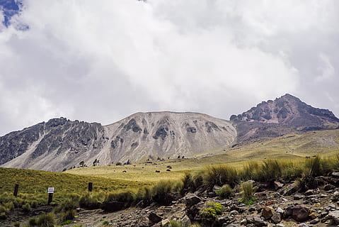 grassfield and mountain, clouds, daylight, field, grass, hill, landscape, mountain, nature, rocks, scenic, sky, summer, tourism, valley, cloud - sky, scenics - nature, beauty in nature, tranquil scene, non-urban scene, tranquility, environment, mountain range, rock, day, no people, remote, idyllic, plant, physical geography, rock - object, formation, outdoors, arid climate, mountain peak, 4K, CC0, public domain, royalty free