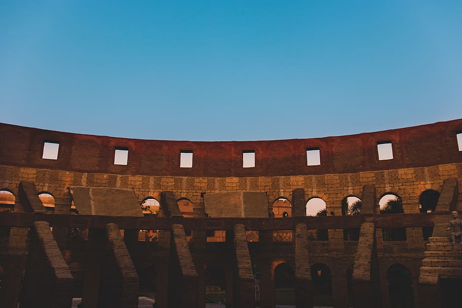 edifici de formigó gris, amfiteatre, arquitectura, edifici, concret, la llum del dia, monument, obert, a l'aire lliure, escultura, estadi, teatre, viatjar, estructura construïda, exterior de l'edifici, cel, cel clar, còpia espai, naturalesa, dia, vista d’angle baix, blau, paret, cap gent, destinacions de viatge, llum solar, barana, turisme, història, arc, columna arquitectònica, 5K