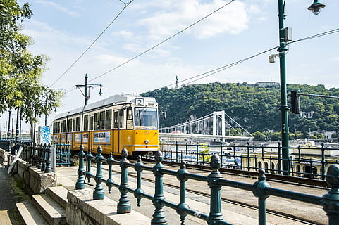 trenino giallo, budapest, tram, mezzi di trasporto, veicolo, treno, Ungheria, funivia, carrello, ringhiera, linea, trasporto, albero, pianta, flora, conifera, urbano, Riva del fiume, pubblico, ponte, cielo, natura, modo di trasporto, trasporto ferroviario, ferrovia, trasporto pubblico, connessione, treno - veicolo, giorno, struttura costruita, nuvola - cielo, traccia, cavo, architettura, acqua, elettricità, all'aperto, Alimentazione elettrica, 5K, CC0, dominio pubblico, privo di copyright