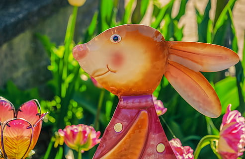easter bunny, easter, figure, doe, cute, easter theme, flowers, colorful, easter decoration, easter greeting, spring, plant, close-up, focus on foreground, representation, no people, growth, art and craft, nature, flower, beauty in nature, day, creativity, flowering plant, toy, freshness, green color, outdoors, animal representation, vulnerability, fragility, 4K, CC0, public domain, royalty free