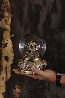 globo di neve cranio, oro, d'oro, nero, decorazione, cranio, Halloween, spaventoso, globo di neve, mano umana, mano, persone reali, una persona, parte del corpo umano, detenzione, stili di vita, orologio, in casa, tempo, parte del corpo, attività di svago, gioielli, uomini, adulto, dito umano, dito, concentrarsi sulle conoscenze acquisite, persona irriconoscibile, color argento, lusso, 5K, CC0, dominio pubblico, privo di copyright