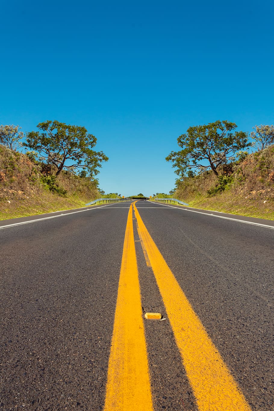 carretera asfaltada, carretera, marcatge de carreteres, signe, transport, marcatge, símbol, direcció, cel, el camí a seguir, doble línia groga, groc, planta, cap gent, perspectiva decreixent, arbre, naturalesa, cel clar, blau, asfalt, línia divisòria, nivell superficial, a l'aire lliure, recta, 5K