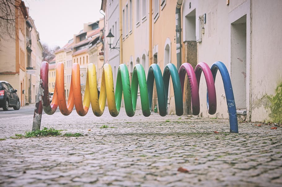 farver, rack, cykler, skærm, by, cykel, multi farvet, bygget struktur, arkitektur, bygning udvendig, dag, i en række, gade, hængende, side om side, udendørs, natur, ingen mennesker, bygning, sti, valg, transportmidler, variation, brosten, tøj, 4K