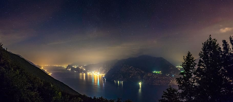 деревья, озеро, свет, города, город, ночь, Nightscape, ночное небо, звезда, звезды, облака, Lake Garda, озеро Гарда, Италия, длительное воздействие, панорама, Лаго ди Гарда, горы, звезда - космос, воды, небо, красота в природе, Scenics - Природа, природа, астрономия, дерево, освещенный, пространство, отражение, спокойствие, галактика, нет людей, спокойная сцена, завод, среда, на открытом воздухе, Млечный Путь, космос и астрономия, 8K