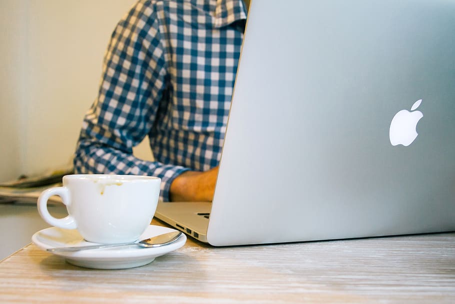 white, ceramic, teacup, beside, silver macbook, table, blur, coffee, communication, connection, cup, data, device, drink, electronic, electronics, gadget, indoors, information, internet, laptop, man, media, office, online, organizer, portable, screen, technology, wood, work, working, mug, coffee cup, food and drink, one person, coffee - drink, crockery, saucer, refreshment, adult, midsection, computer, casual clothing, business, wireless technology, hot drink, tea cup, 4K
