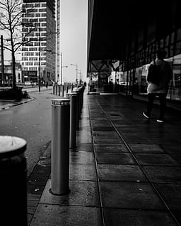 gray metal column, path, person, human, clothing, apparel, footwear, shoe, sidewalk, sweden, pavement, malmo, pedestrian, walkway, handrail, banister, street, metal, dark, moody, black, building exterior, city, architecture, built structure, footpath, one person, full length, city life, building, real people, walking, rear view, day, incidental people, men, the way forward, transportation, direction, outdoors, 4K, CC0, public domain, royalty free