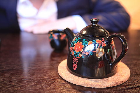 teapot, hand, close-up, table, focus on foreground, indoors, food and drink, no people, drink, kettle, tea - hot drink, wood - material, tea, cup, hot drink, crockery, handle, mug, illuminated, shiny, container, tea cup, silver colored, pitcher - jug, coffee pot, 720P, CC0, public domain, royalty free