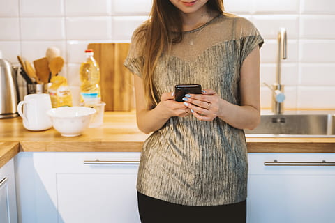 woman texting, smart, phone, kitchen, one person, indoors, technology, midsection, women, domestic kitchen, home, lifestyles, adult, connection, real people, young adult, casual clothing, wireless technology, holding, standing, hairstyle, young women, 5K, CC0, public domain, royalty free