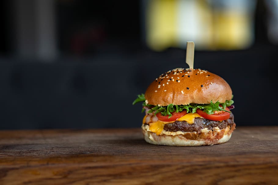 foto de primer pla, hamburguesa, pa, bun, formatge, cheeseburger, primer pla, deliciós, menjar ràpid, menjar, fotografia de menjar, enciam, dinar, llavors de sèsam, saborós, tomàquet, menjar i beguda, entrepà, menjar poc saludable, vegetals, llest per menjar, carn, material de fusta, frescor, taula, gourmet, cap gent, treureu menjar, berenar, sopar, decorar, 5K