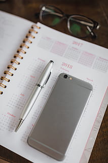 pink calendar, calendar, notebook, diary, note, desk, communication, glasses, table, still life, wireless technology, paper, pen, publication, eyeglasses, close-up, book, high angle view, education, portable information device, indoors, note pad, no people, technology, mobile phone, smart phone, personal accessory, 5K, CC0, public domain, royalty free