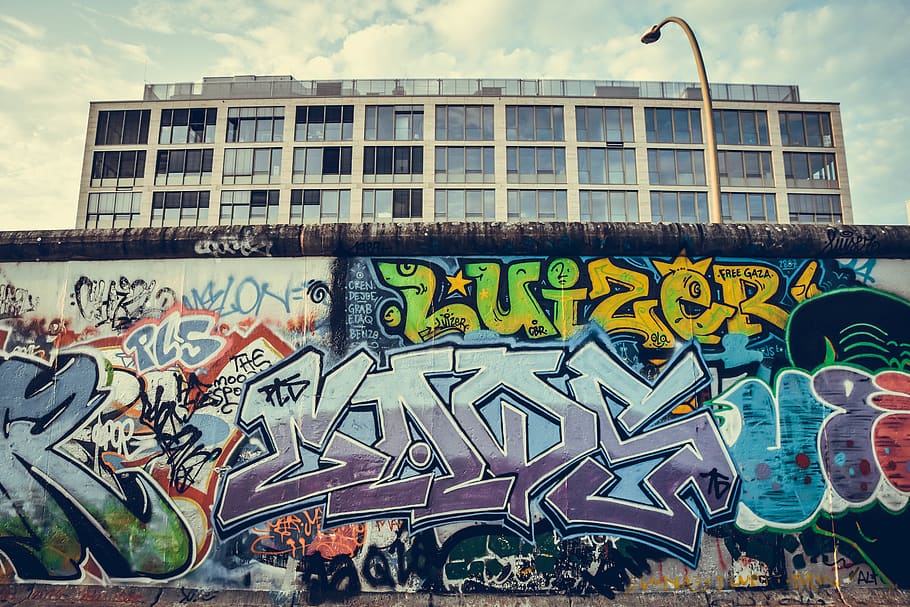 graffiti murali multicolori, graffiti, annuncio pubblicitario, manifesto, arte, parete, pittura, murale, umano, persona, macchina, ruota, Berlino, etichetta, muro di Berlino, ginocchio, disegno, capi di abbigliamento, abbigliamento, seta, sari, architettura, struttura costruita, esterno dell'edificio, arte e artigianato, giorno, testo, creatività, sceneggiatura occidentale, nuvola - cielo, cielo, nessuno, multicolore, arte di strada, comunicazione, natura, all'aperto, rappresentazione, rappresentazione umana, città, 5K