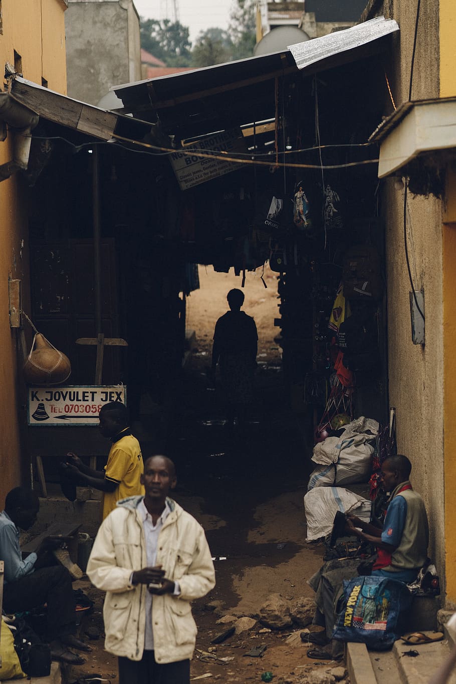 home, portar, blanc, jaqueta, humà, persona, roba, portal fort, mobles, cadira, edifici, Àfrica, uganda, urbà, arquitectura, màquina, va parlar, abric, mercat, basar, botiga, pneumàtic, ciutat, homes, persones reals, grup de persones, gent, estructura construïda, exterior de l'edifici, ocupació, negocis, assegut, dones, dia, de peu, estils de vida, adult, treball, negoci petit, mascles, desordenat, 2K