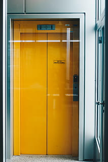 lukket gul elevator, indgang, dør, ingen mennesker, arkitektur, gul, moderne, indendørs, meddelelse, bygget struktur, glas - materiale, elevator, lukket, dag, forretning, bygning, murbygningsfunktion, fravær, kontor, tekst, stål, 5K, CC0, offentligt domæne, royaltyfrie