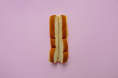 dos pa de pa, menjar i beguda, menjar, tir de l'estudi, fons de colors, a l'interior, alimentació saludable, sol objecte, color rosa, frescor, benestar, berenar, cap gent, fons rosa, tallar, senzillesa, primer pla, còpia espai, indulgència, menjar ràpid, gos calent, temptació, 5K, CC0, domini públic, lliure de regalies