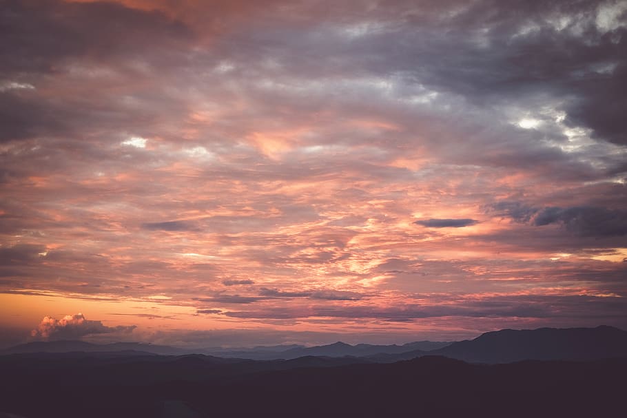 mountains during sunset, nature, outdoors, sky, cloud, dawn, sunset, dusk, red sky, sunrise, mountain, mountain range, weather, cumulus, scenery, peak, landscape, sunlight, horizon, panoramic, countryside, cloud - sky, beauty in nature, scenics - nature, tranquility, tranquil scene, orange color, dramatic sky, environment, idyllic, no people, awe, silhouette, majestic, bright, 4K