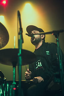 Mann, spiller, tromme, sang, musiker, musikk Instrument, menneskelig, person, perkusjon, trommeslager, konsert, konsertfotografering, trommer, rød, clubz, gul, grønn, hatt, klær, publikum, ansikt, rockekonsert, musikk, én person, ekte folk, unge menn, menn, kunstkultur og underholdning, ung voksen, innendørs, sitter, percussion instrument, holding, livsstil, fornøyelse, trommeslaginstrument, kunstner, okkupasjon, ferdighet, 4K, CC0, offentlig domene, opphavsrett gratis