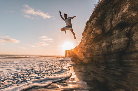 man hoppar, klippa, vatten, strand, moln, roligt, gyllene timmen, hoppning, landskap, man, natur, hav, sand, marinmålning, havsstrand, himmel, Sol, solstrålar, solnedgång, vågor, skönhet i naturen, sten, scenics - natur, fast, rock-objekt, landa, rörelse, horisont, horisont över vatten, sten formation, moln - himmel, icke-urbana scenen, mänsklig arm, armar uppvuxna, 5K, CC0, offentligt domän, royaltyfria