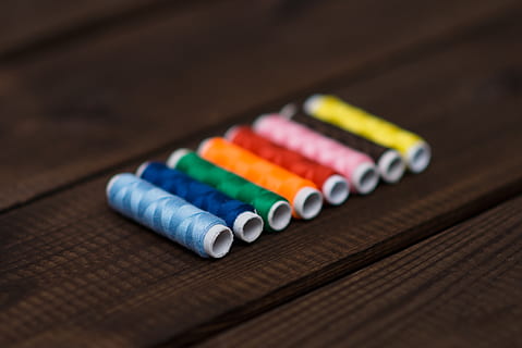 thread, spools, string, sewing, colors, colours, multi colored, variation, choice, close-up, table, indoors, no people, in a row, art and craft, wood - material, selective focus, pencil, still life, focus on foreground, craft, vibrant color, writing instrument, creativity, group of objects, order, colored pencil, art and craft equipment, 2K, CC0, public domain, royalty free