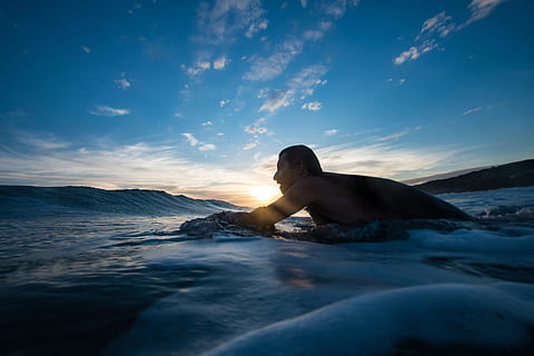 man surfing, blue, hour, beach, clouds, dusk, evening, man, ocean, outdoors, sea, seafoam, seascape, seashore, sky, sunrays, sunset, surf, surfing, water, waves, one person, leisure activity, nature, lifestyles, adult, shirtless, beauty in nature, young adult, real people, scenics - nature, holiday, cloud - sky, trip, 2K, CC0, public domain, royalty free