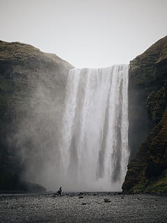 persona, in piedi, cascate, cascata, spruzzo, scogliere, acqua, caduta, paesaggio, Islanda, nuvoloso, giorno nuvoloso, strato orizzontale, paesaggio islandese, grigio, freddo, natura, skogafoss, foss, Paesaggi, fiume, posto famoso, all'aperto, cascate del Niagara, viaggio, iguazu cade, soggezione, gullfoss cade, cascata di skógafoss, bellezza nella natura, destinazioni di viaggio, turismo, parco nazionale di iguacu, maestoso, Godafoss cade, energia, scogliera, roccia - oggetto, montagna, cielo, punto di riferimento nazionale, estate, cascata di seljalandsfoss, spray, fiume iguacu, nessuno, 4K, CC0, dominio pubblico, privo di copyright