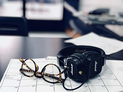 auriculares marshall negros, fondo borroso, calendario, escritorio, electrónica, los anteojos, auriculares, adentro, números, el plastico, tecnología, centrarse en primer plano, equipo fotográfico, de cerca, camara - equipo fotografico, una persona, mesa, moderno, equipo, temas de fotografia, gente real, mueble, de color negro, salud y medicina, cámara, oficina, cámara digital, 4K, CC0, dominio público, libre de derechos