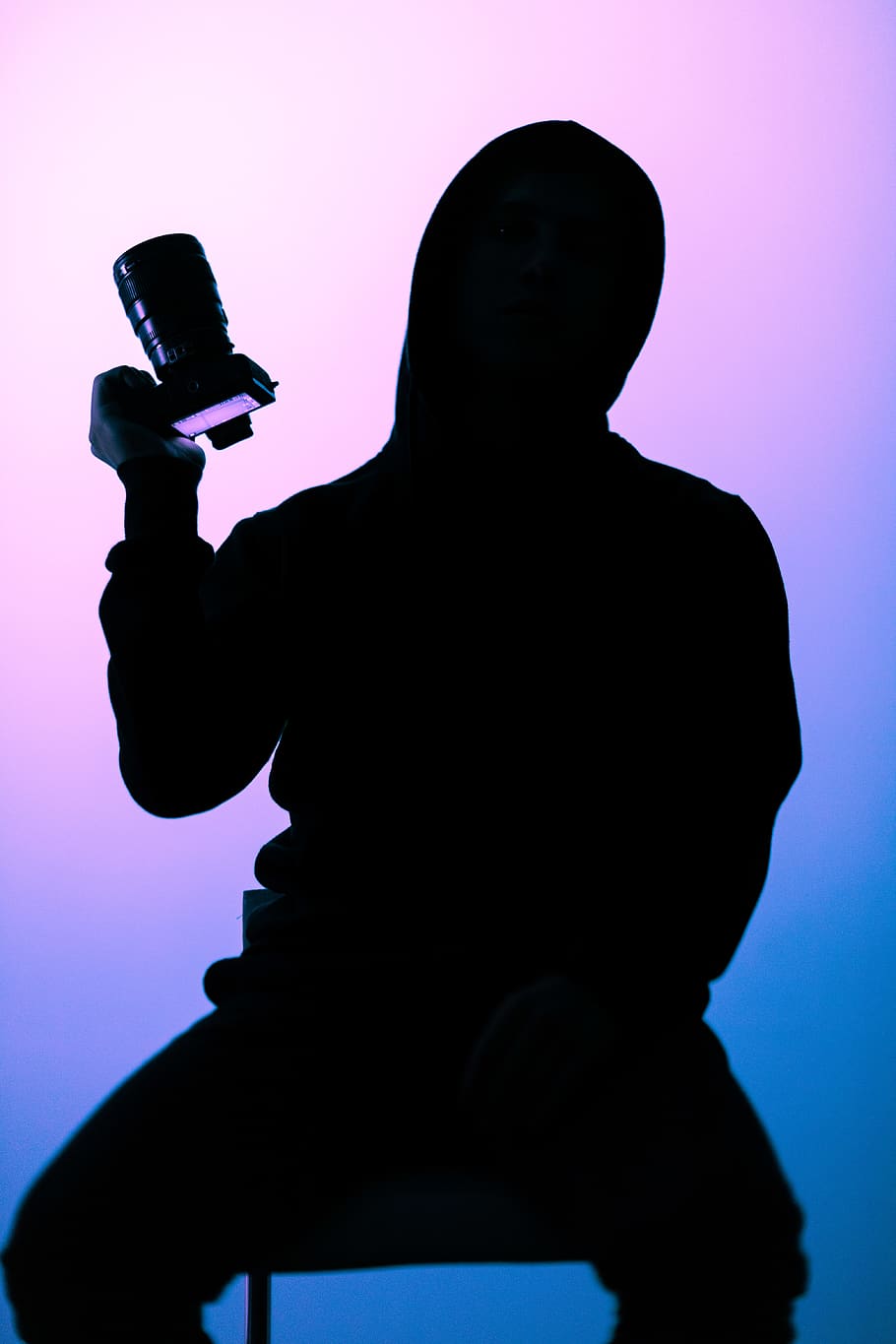fotografia di silhouette, persona, detenzione, fotocamera reflex, retroilluminato, telecamera, avvicinamento, buio, moda, luci, modello, indossare, silhouette, una persona, in casa, girato in studio, uomini, sfondo colorato, tre quarti, in piedi, vista frontale, parte del corpo umano, adulto, musica, blu, Esprimere a gesti, ritratto, cultura artistica e intrattenimento, dalla vita in su, stili di vita, viola, aggressione, sfondo blu, 5K