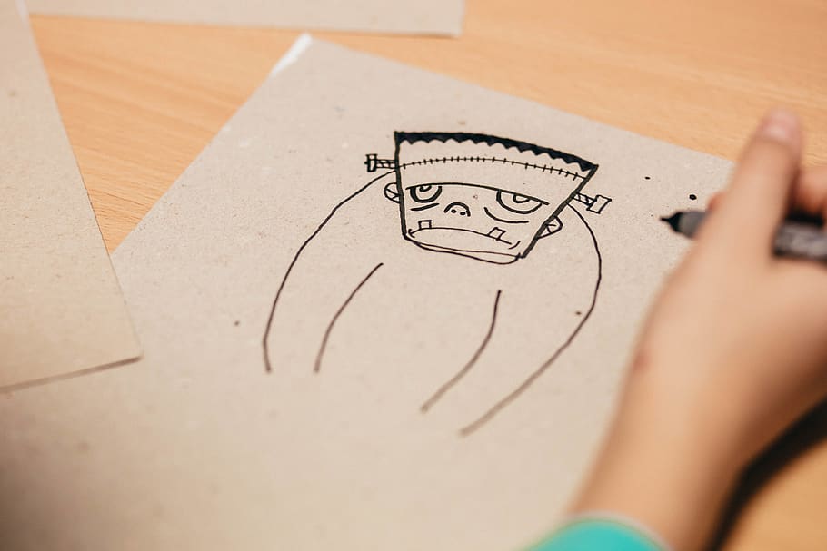 noi, dibuixa, figura de personatge de dibuixos animats, borrós, primer pla, composició, conceptual, escriptori, dibuix, educació, focus, mà, bolígraf, fusta, escriure, creativitat, art i artesania, activitat, paper, una persona, dibuix - activitat, esbós, dibuix - producte artístic, mà humana, part del cos humà, a l'interior, celebració, habilitat, artista, enfocament selectiu, representació, llapis, dibuix a llapis, 5K