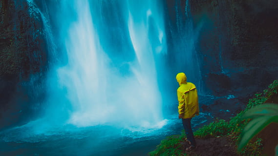 dramatic, waterfall, mist, man, yellow, jacket, waterproof, mountain, travel, adventure, vacation, hike, full length, one person, standing, clothing, water, nature, cave, rear view, outdoors, smoke - physical structure, rock - object, rock, exploration, adult, tourism, travel destinations, mystery, 2K, CC0, public domain, royalty free