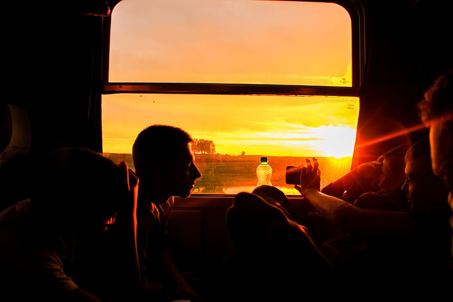 silueta, home, assegut, posta de sol, retroil·luminat, mòbil, núvols, fosc, tarda, paisatge, naturalesa, gent, cel, sol, raigs solars, prendre fotos, sistema de transport, color taronja, grup de persones, finestra, persones reals, homes, activitat d'oci, dones, adult, estils de vida, núvol - cel, viatjar, a l'aire lliure, multitud, relaxació, 5K