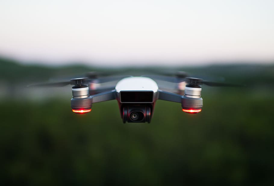 quadcopter de plata, cap gent, centrar-se en primer pla, dia, a l'aire lliure, naturalesa, cel, volant, moviment, a l'aire, transport, moviment borrós, primer pla, tecnologia, color negre, llum solar, drone, control, vermell, manera de transport, enfocament selectiu, 4K