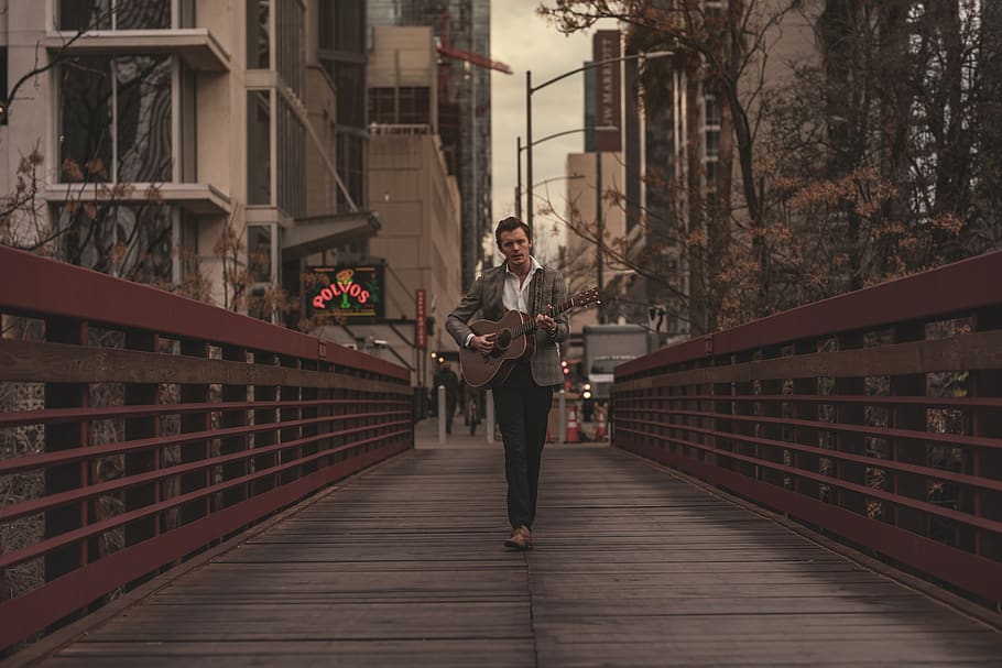 Mann, spielen, Gitarre, Steg, die Architektur, Brücke, Gebäude, Stadt, Tageslicht, Unterhaltung, Gitarrist, Kerl, Instrument, männlich, männliches Model, Musik-, Musikinstrument, Musiker, Künstler, Person, Straße, Straßenmusiker, Strassenfotografie, Saiteninstrument, tragen, eine Person, gebaute Struktur, in voller Länge, echte Menschen, Freizeitbeschäftigung, junger Erwachsener, Lebensstile, Legere Kleidung, Geländer, Stehen, Gebäudehülle, Vorderansicht, halten, junge Frau, der Weg nach vorn, Fußweg, Erwachsene, draußen, 8K