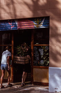 woman, standing, beside, door, sunlight, person, shop, store, crate, box, shopfront, storefront, plant, window, girl, leg, street photography, denim short, nursery, lady, ladies, shoe, feet, people, men, editorial, outdoors, women, urban Scene, lifestyles, 5K, CC0, public domain, royalty free