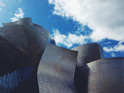 edifici de formigó gris, arquitectura, estructura construïda, exterior de l'edifici, cel, núvol - cel, vista d’angle baix, naturalesa, dia, llum solar, cap gent, edifici, ciutat, a l'aire lliure, destinacions de viatge, modern, blau, exterior d’edifici d’oficines, indústria, paret, reflexió, gratacels, 2K, CC0, domini públic, lliure de regalies